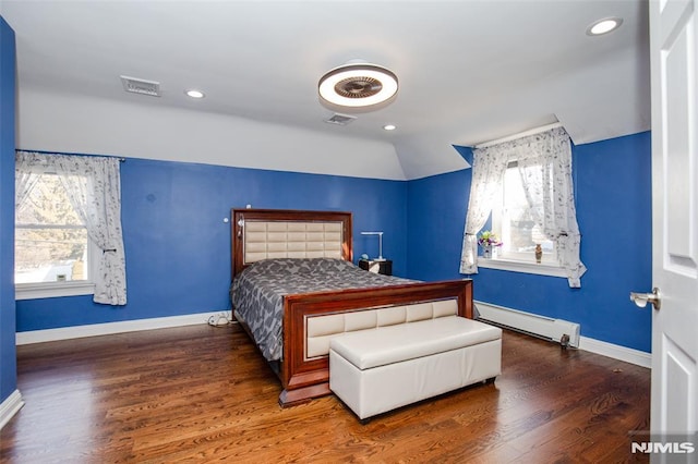 bedroom featuring a baseboard heating unit, vaulted ceiling, and dark wood-type flooring