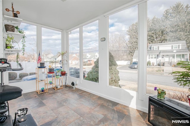 sunroom featuring heating unit and a wealth of natural light