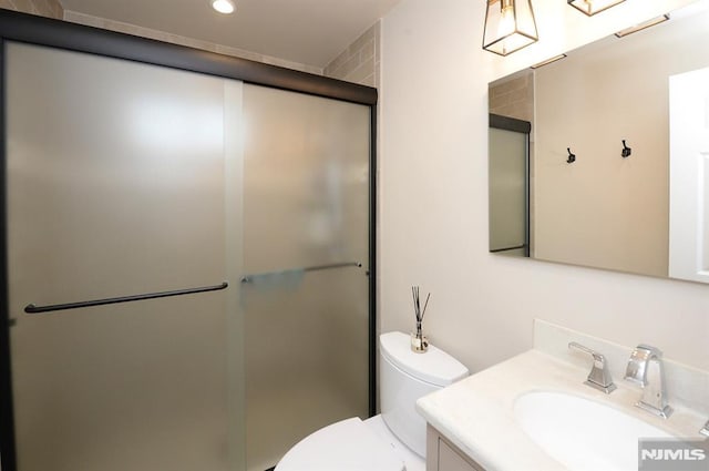 bathroom with vanity, toilet, and an enclosed shower