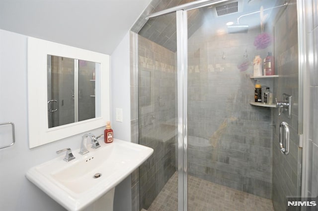 bathroom with an enclosed shower and sink