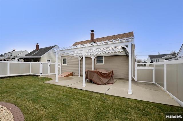 rear view of property with a yard, a pergola, and a patio