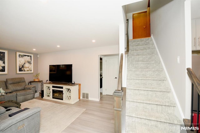 living room featuring a fireplace and light hardwood / wood-style flooring