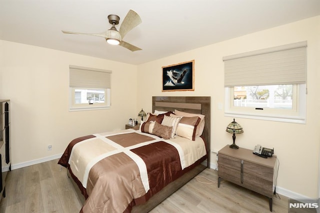 bedroom with multiple windows, ceiling fan, and light hardwood / wood-style flooring