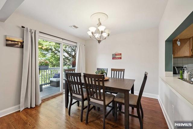 dining area featuring dark wood-type flooring and an inviting chandelier