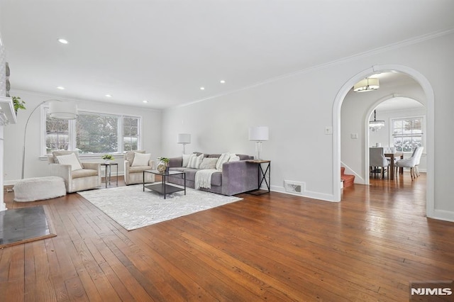 unfurnished living room featuring dark wood-type flooring and crown molding