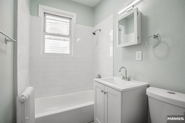 full bathroom with radiator, vanity, a healthy amount of sunlight, and tiled shower / bath