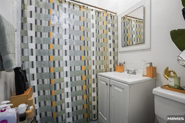 bathroom featuring vanity, toilet, and walk in shower