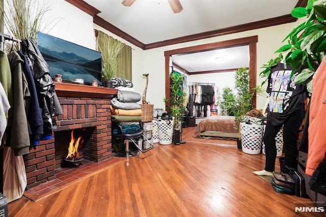 interior space featuring a fireplace, ceiling fan, hardwood / wood-style floors, and ornamental molding