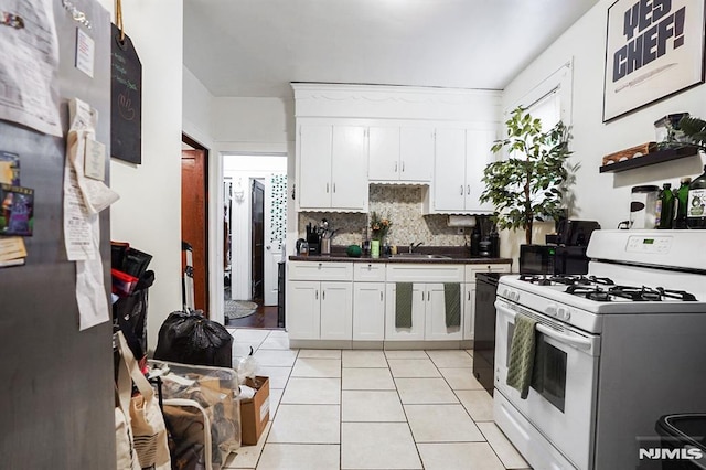 kitchen with backsplash, white cabinets, sink, light tile patterned floors, and gas range gas stove