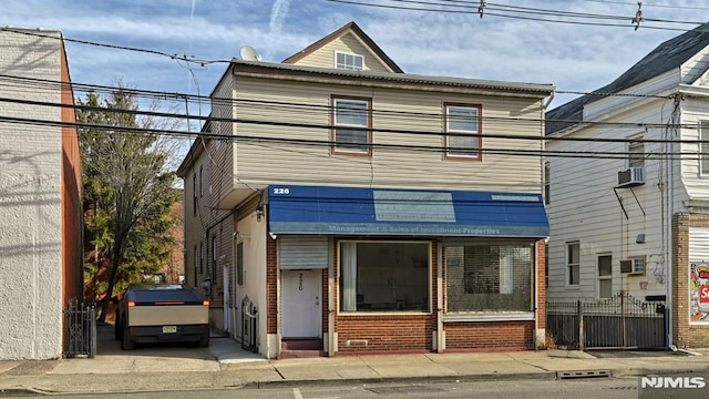 view of front of home featuring an AC wall unit