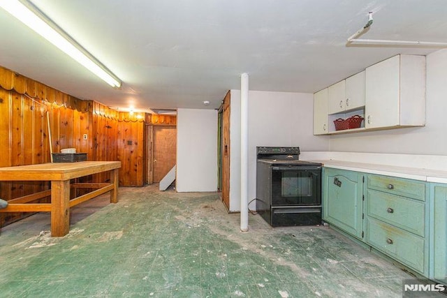 kitchen featuring electric range, white cabinets, wooden walls, and green cabinets