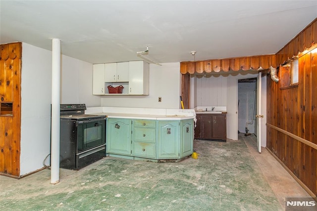 kitchen featuring wood walls, black / electric stove, green cabinets, white cabinets, and sink