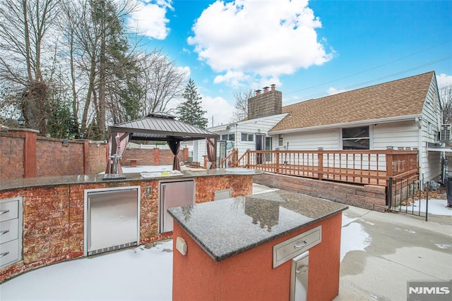 view of patio with a deck, exterior kitchen, and a gazebo