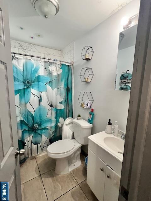 bathroom with toilet, vanity, tile patterned flooring, and a shower with shower curtain