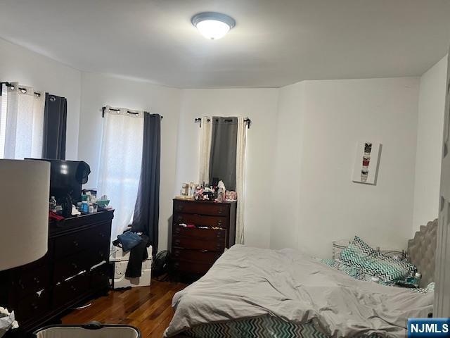 bedroom with dark wood-type flooring