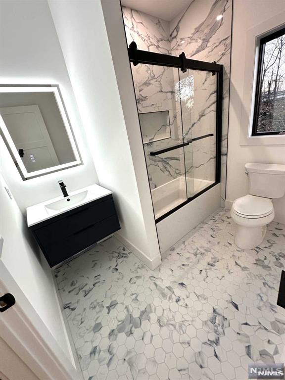 full bathroom with shower / bath combination with glass door, vanity, and toilet