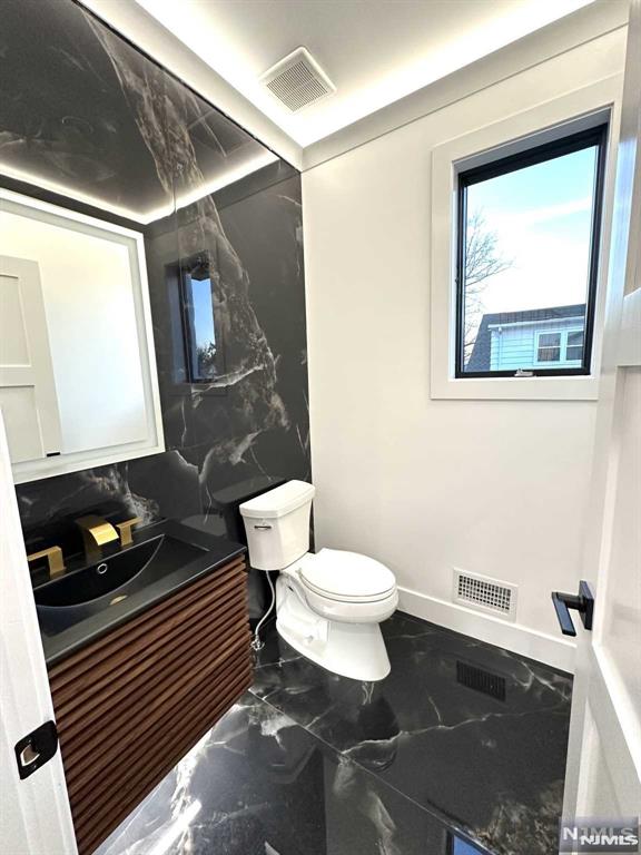 bathroom featuring vanity and toilet