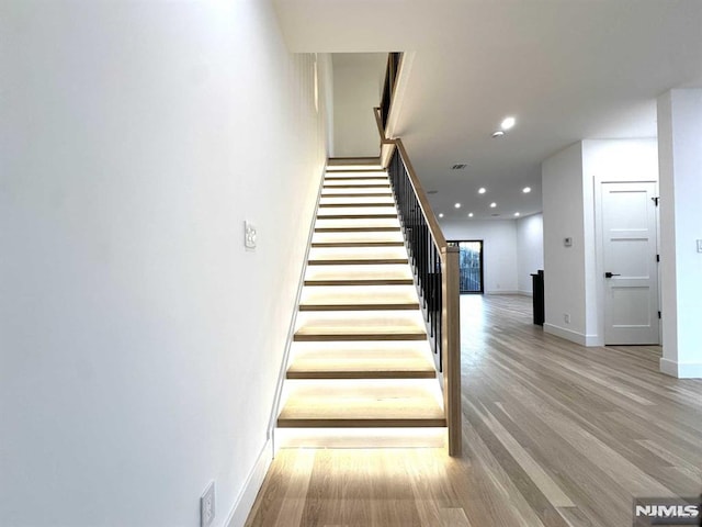 staircase with hardwood / wood-style flooring