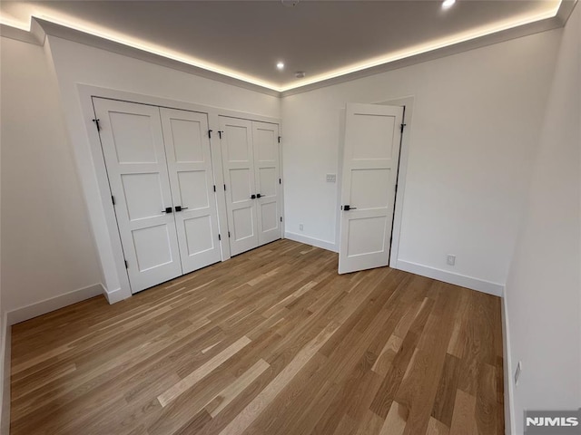 unfurnished bedroom with multiple closets and light hardwood / wood-style floors