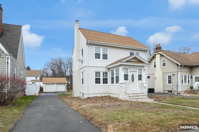 view of front of house with an outbuilding, a front yard, and a garage