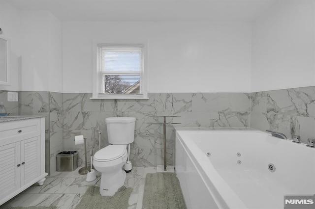 bathroom featuring vanity, toilet, tile walls, and a washtub