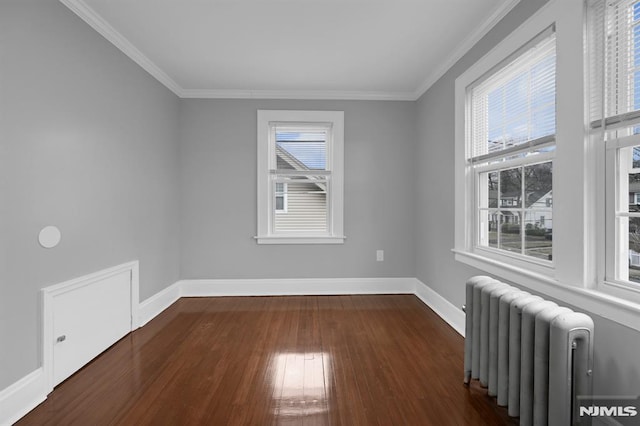 unfurnished room with radiator heating unit, ornamental molding, and dark wood-type flooring