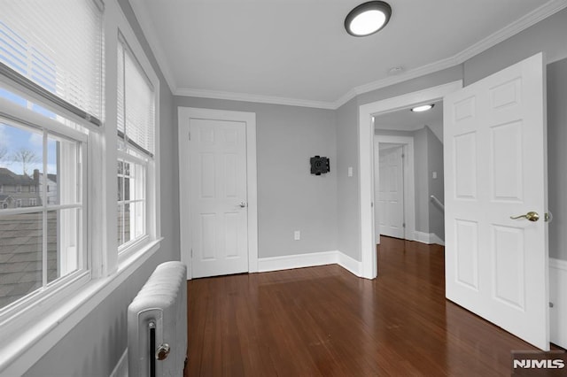 unfurnished bedroom with radiator heating unit, dark hardwood / wood-style flooring, and ornamental molding