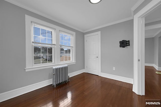 empty room featuring radiator heating unit, dark wood-type flooring, and crown molding