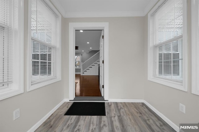 doorway with crown molding and hardwood / wood-style flooring