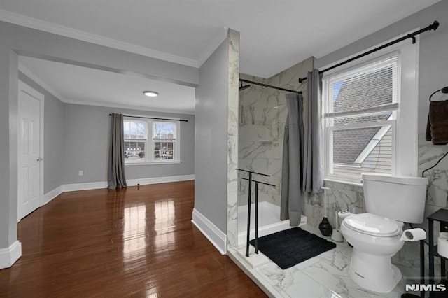 bathroom featuring a shower with shower curtain, toilet, and ornamental molding