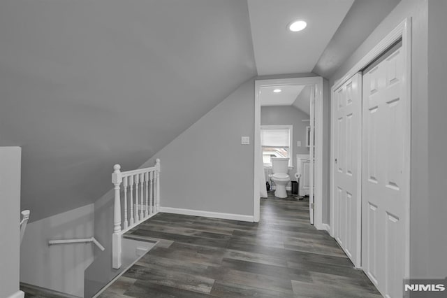 hall with dark hardwood / wood-style flooring and lofted ceiling