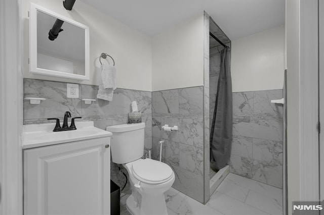 bathroom featuring vanity, curtained shower, toilet, and tile walls