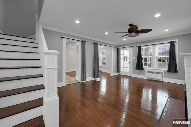 unfurnished living room with ceiling fan, dark hardwood / wood-style floors, ornamental molding, and radiator