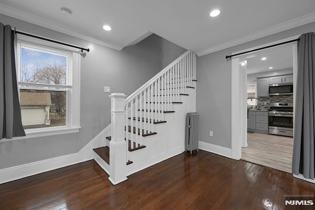 stairway with hardwood / wood-style floors, plenty of natural light, and crown molding