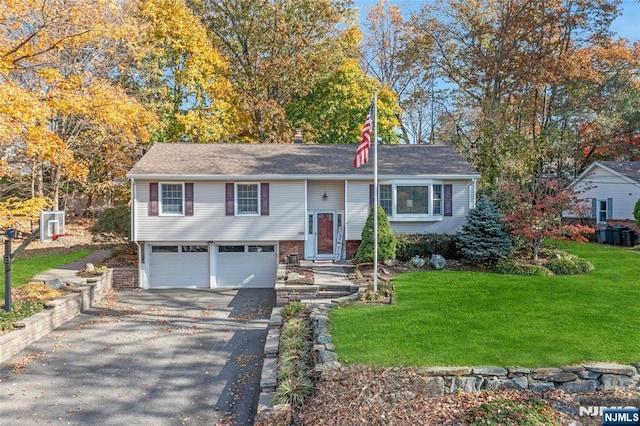 split foyer home featuring a garage and a front lawn