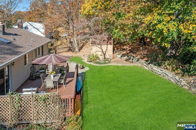 view of yard with a wooden deck and a storage shed