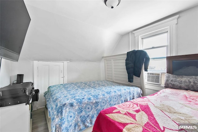 bedroom with hardwood / wood-style floors, cooling unit, and vaulted ceiling