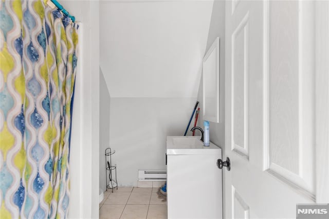 bathroom featuring vanity, lofted ceiling, a baseboard heating unit, a shower with curtain, and tile patterned flooring