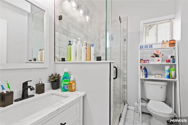 bathroom featuring vanity, toilet, and a shower with door