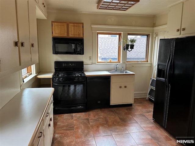 kitchen with dark tile patterned flooring, black appliances, and sink