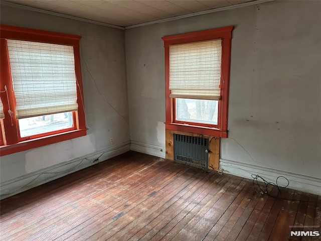 spare room featuring ornamental molding, hardwood / wood-style floors, and radiator