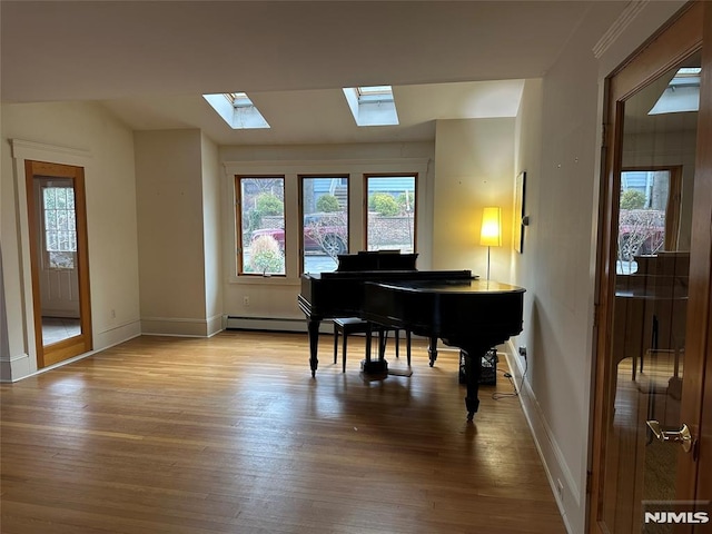 miscellaneous room with a skylight and light wood-type flooring