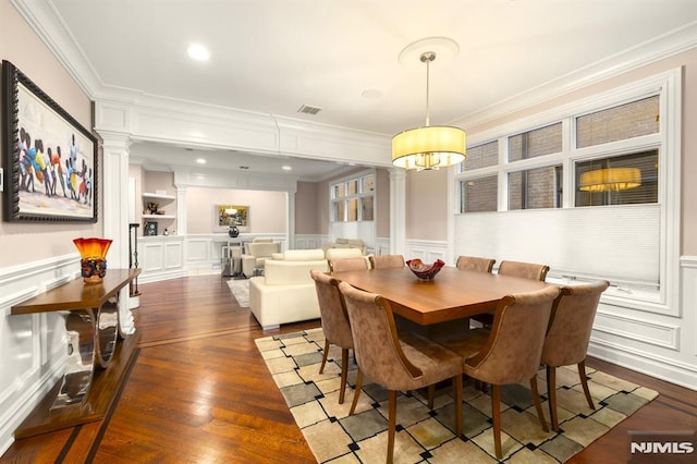 dining area with ornamental molding, dark hardwood / wood-style floors, and ornate columns