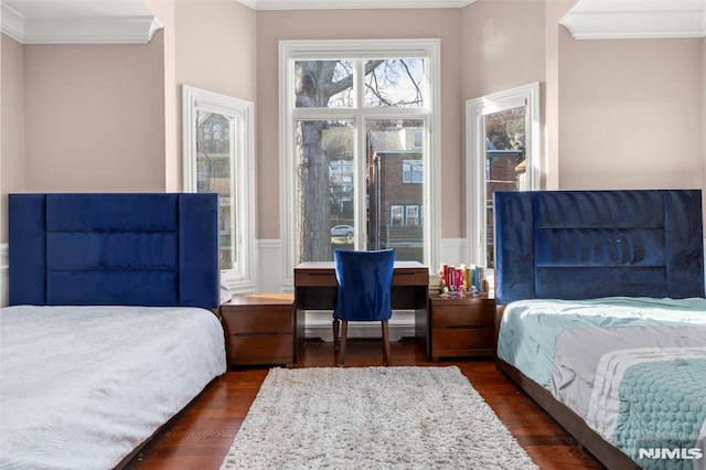 bedroom with ornamental molding, dark hardwood / wood-style floors, and a baseboard heating unit