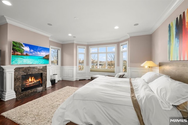 bedroom with ornamental molding, dark hardwood / wood-style flooring, and a high end fireplace