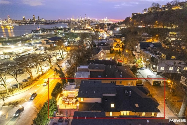 aerial view at dusk featuring a water view