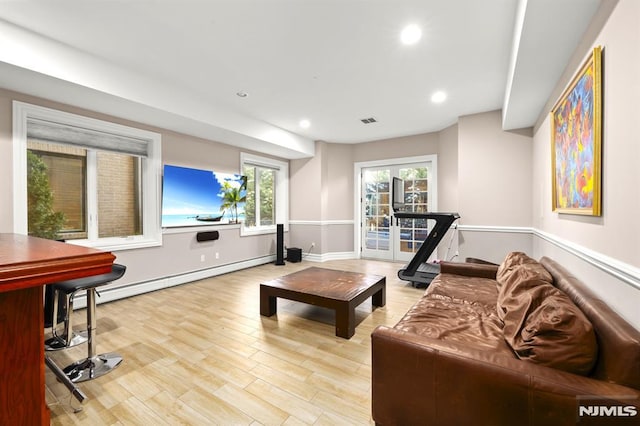 living room with light hardwood / wood-style floors and a baseboard heating unit