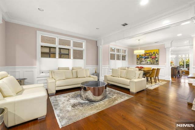 living room with ornate columns, dark hardwood / wood-style flooring, and crown molding