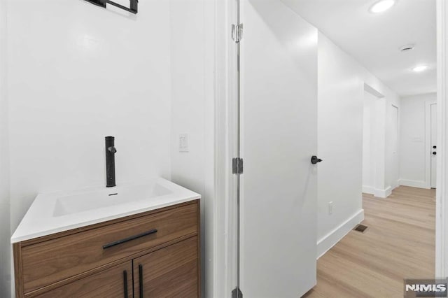 bathroom with hardwood / wood-style floors and vanity