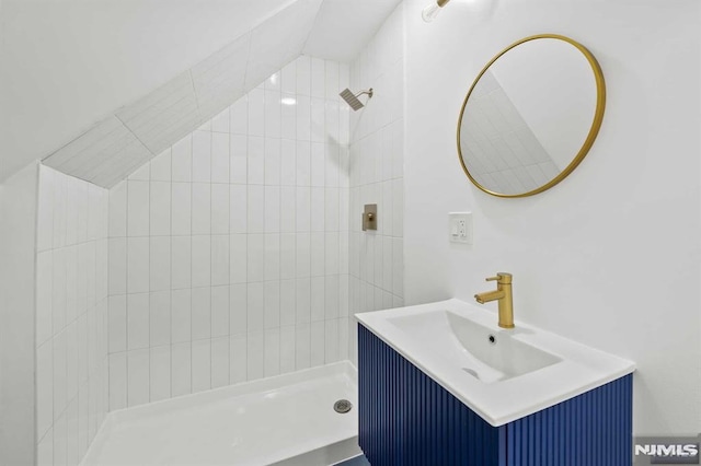 bathroom with vanity and tiled shower